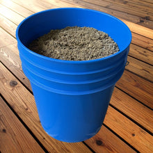 Load image into Gallery viewer, 5-gallon blue bucket containing 25 lbs of dried fish material on wooden deck flooring
